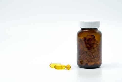 Yellow fish oil capsule pills with amber glass bottle